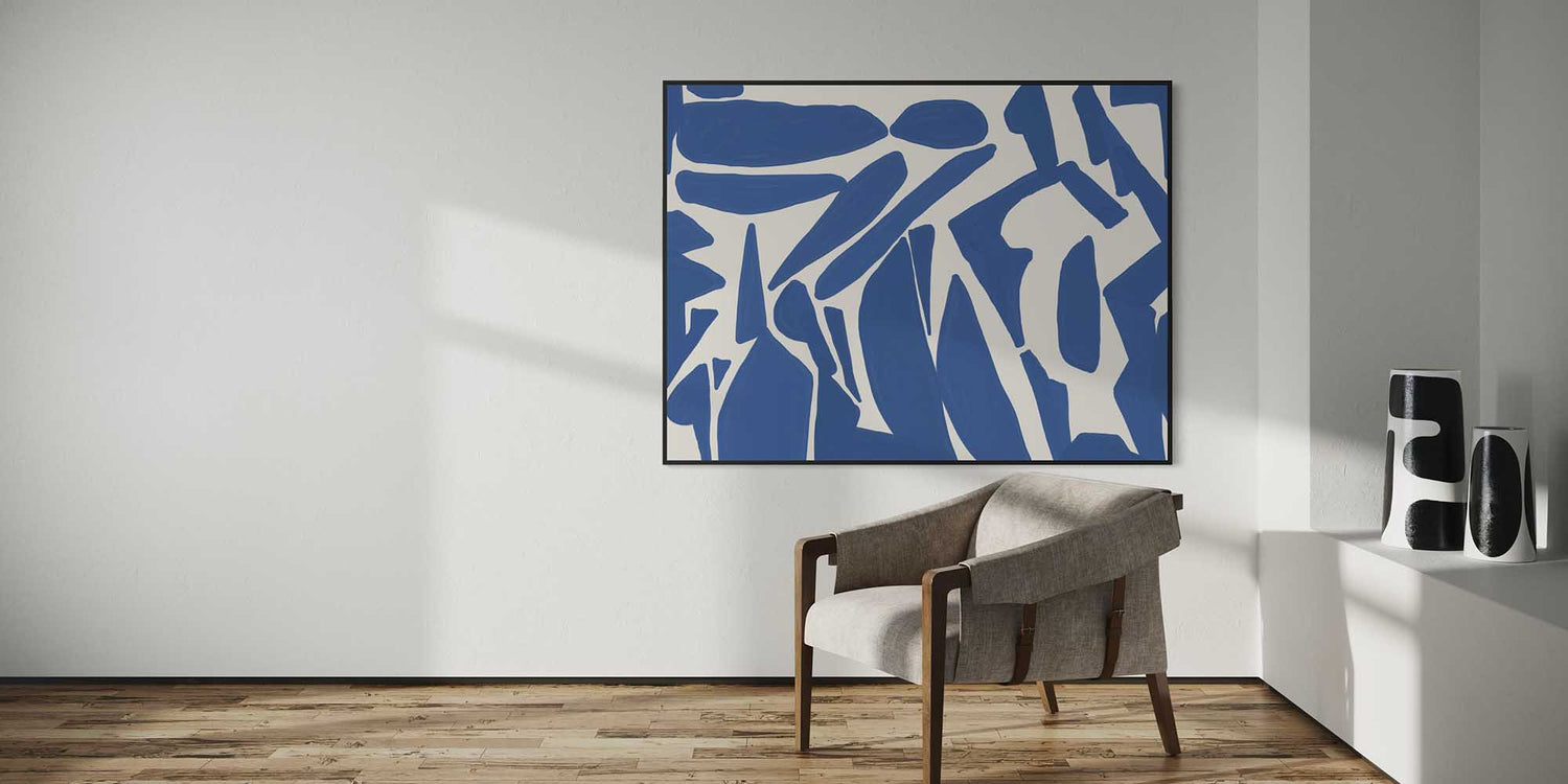 Abstract blue and white painting on a wall in a modern room with a chair and speakers.