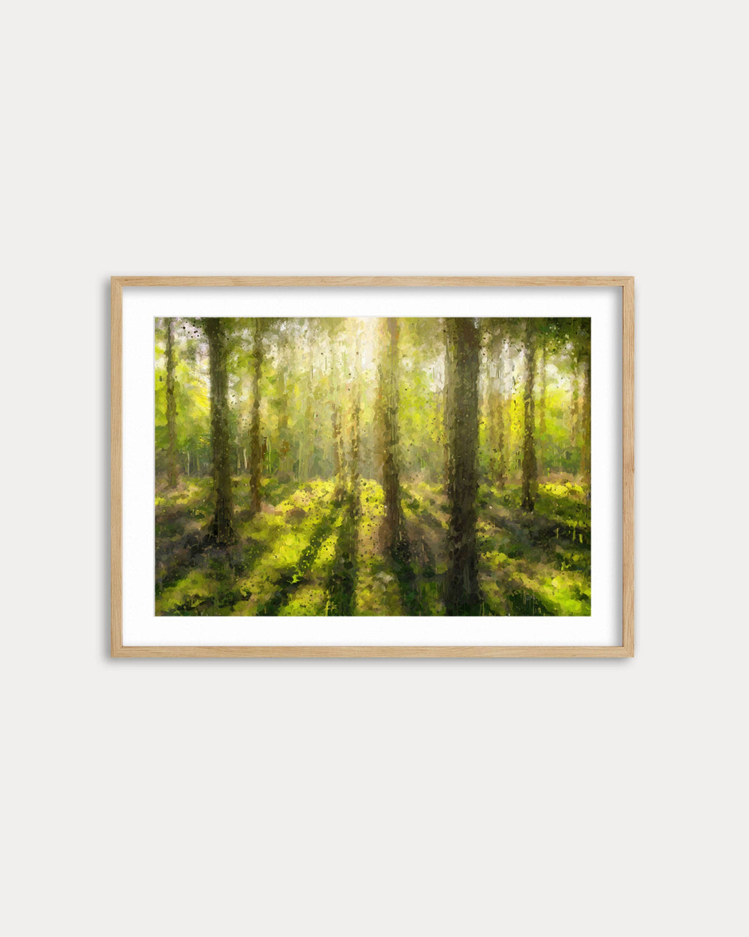 Framed artwork of a forest scene with sunlight filtering through the trees on a white wall.