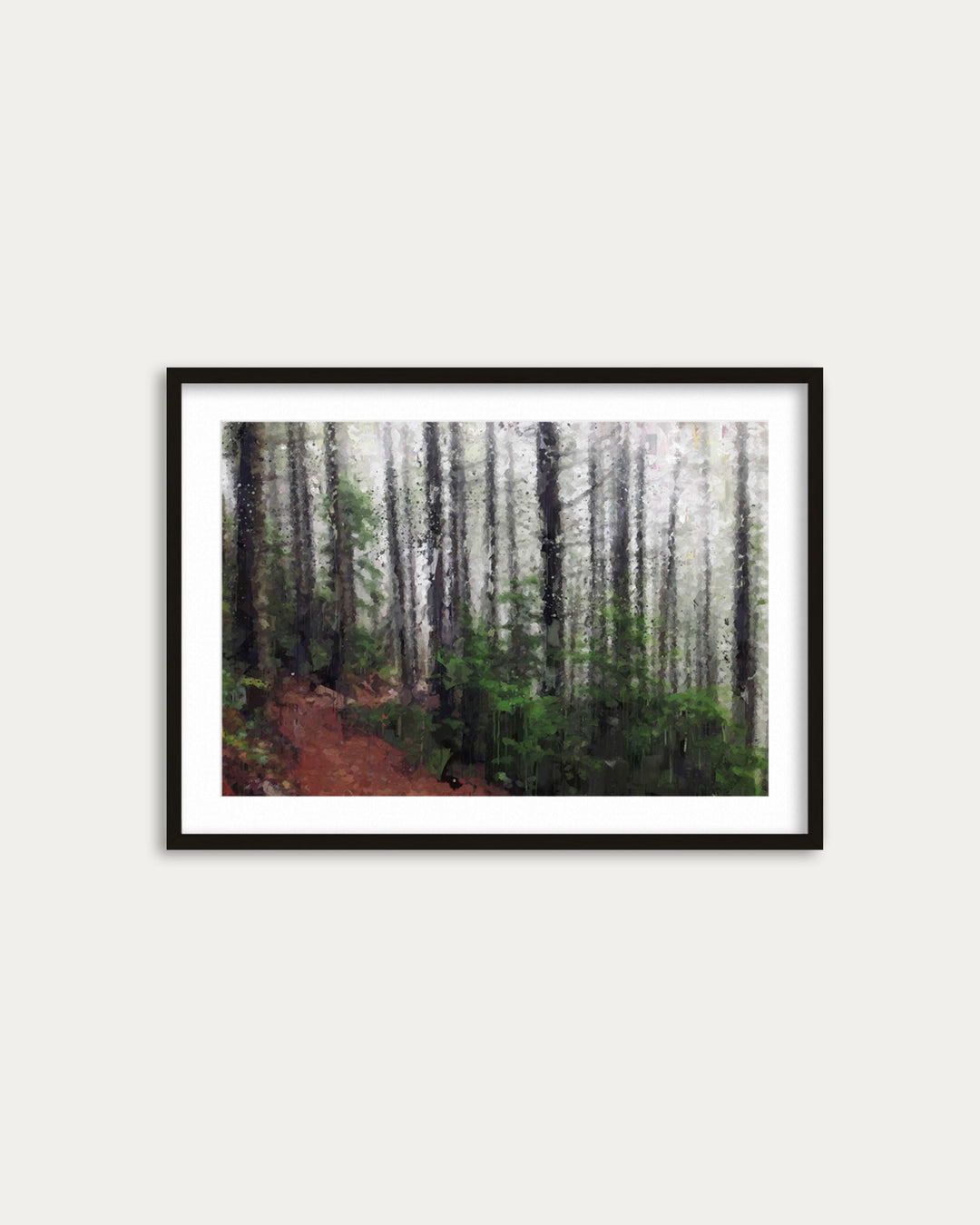 Framed photograph of a forest path on a white wall