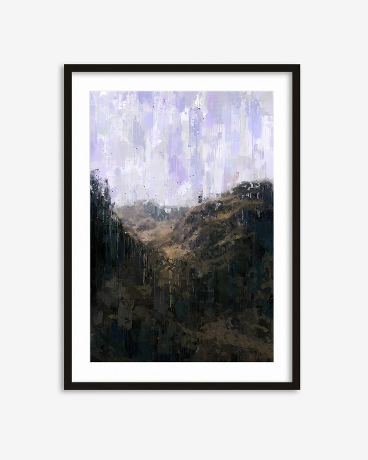Framed artwork of a mountain landscape with a cloudy sky.