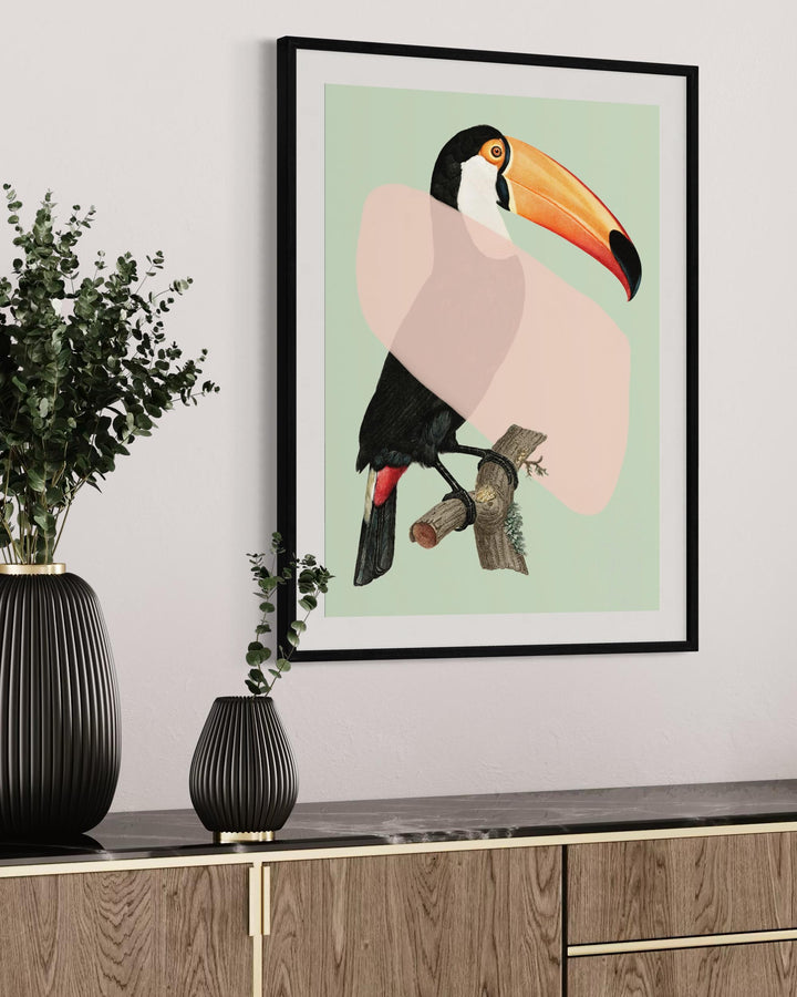 Framed artwork of a toucan on a wall above a wooden cabinet with decorative vases.