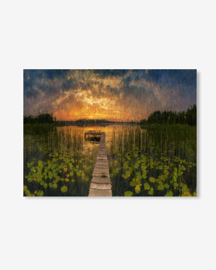Wooden dock extending into a lake with a sunset sky