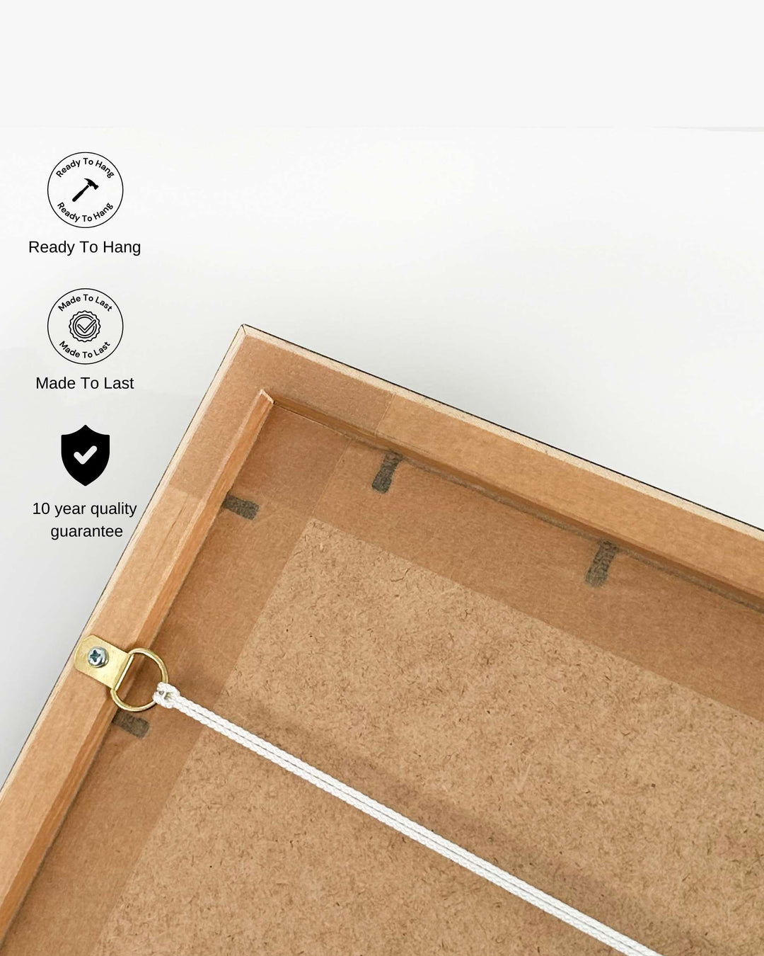 Back of a wooden picture frame with hanging hardware on a white background