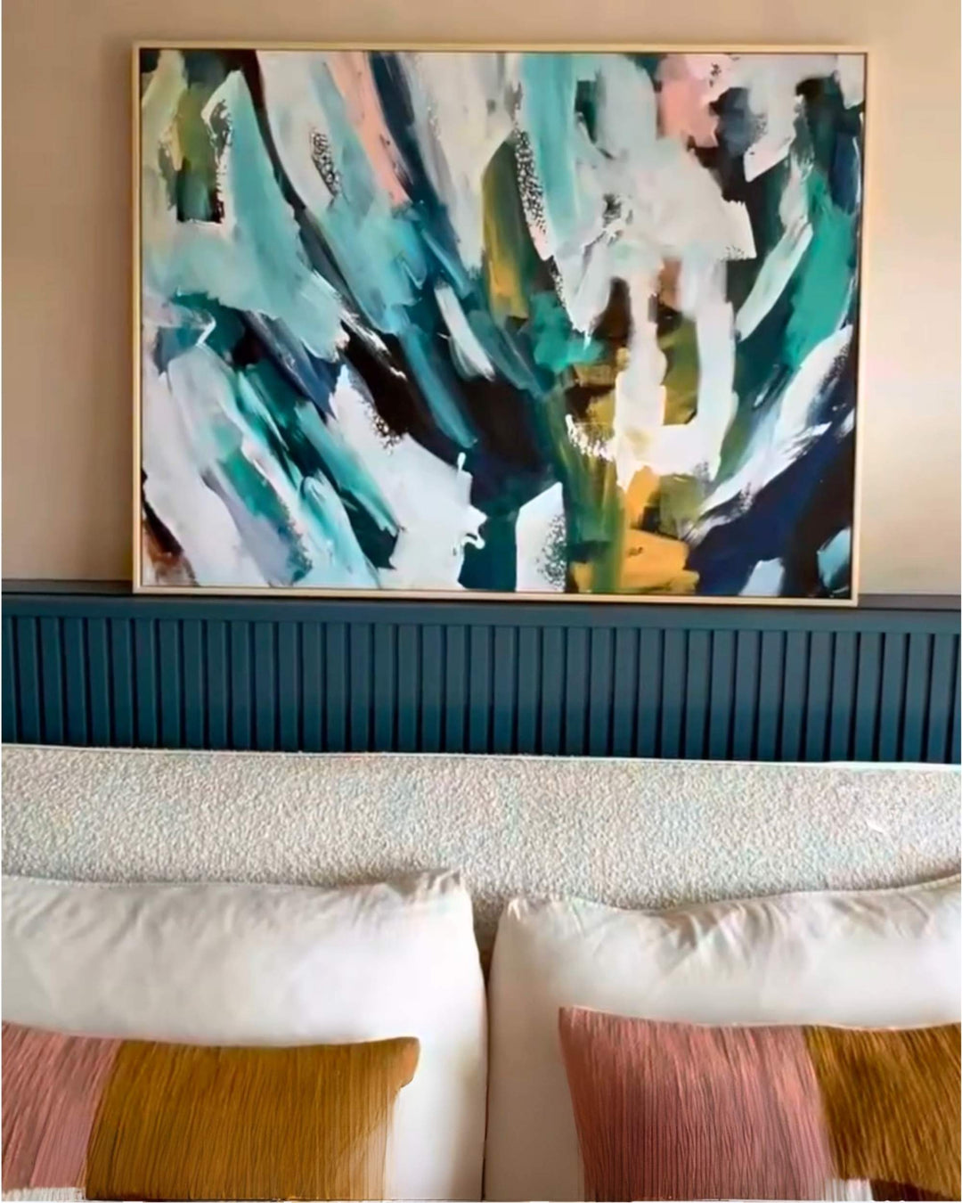 Abstract painting above a sofa with decorative pillows