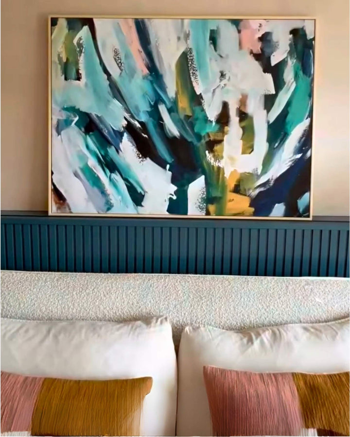 Abstract painting above a sofa with decorative pillows