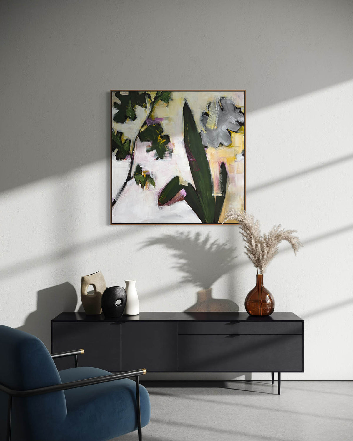 An abstract floral painting with green leaves, gray flowers, and yellow accents, displayed on a light gray wall above a black sideboard in a modern living room setting.