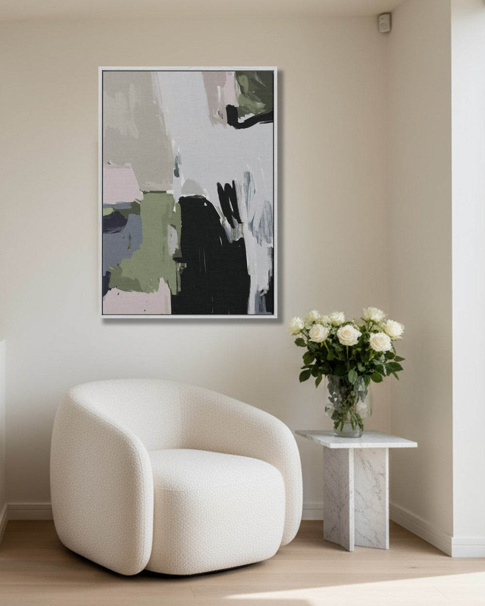 Modern interior with a white armchair, abstract art on the wall, and a small table with flowers.