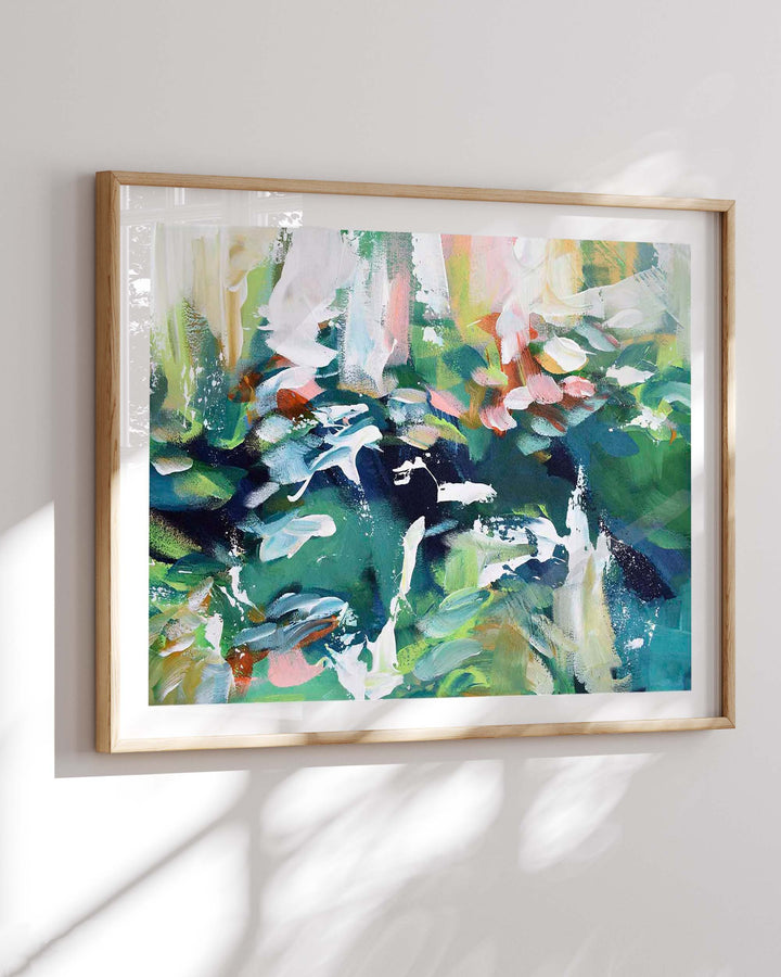 Framed abstract painting with colorful brushstrokes on a white wall