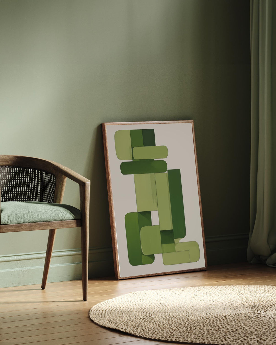 Framed abstract art with green shapes leaning against a wall next to a chair.