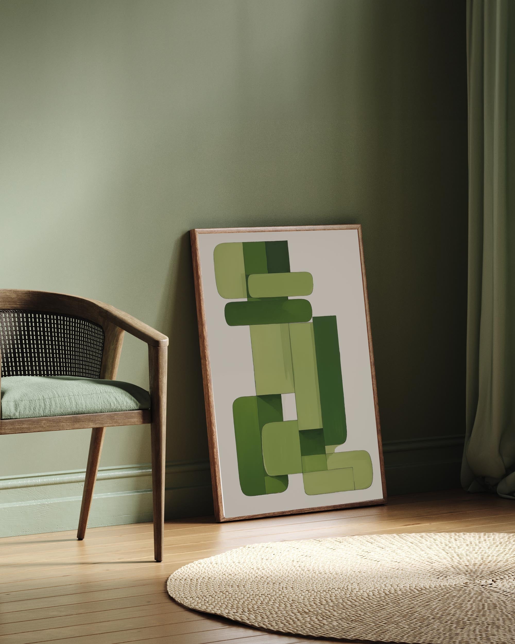 Framed abstract art with green shapes leaning against a wall next to a chair.