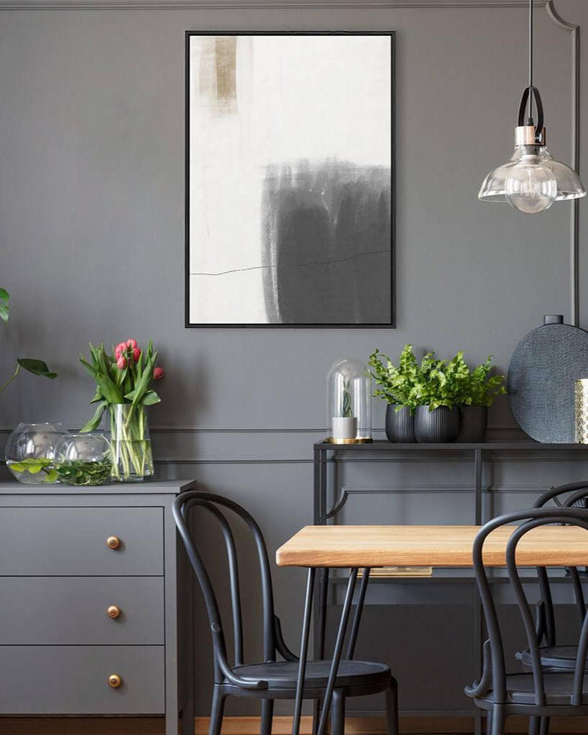 Dining room with abstract art on the wall, table, chairs, and decorative elements.