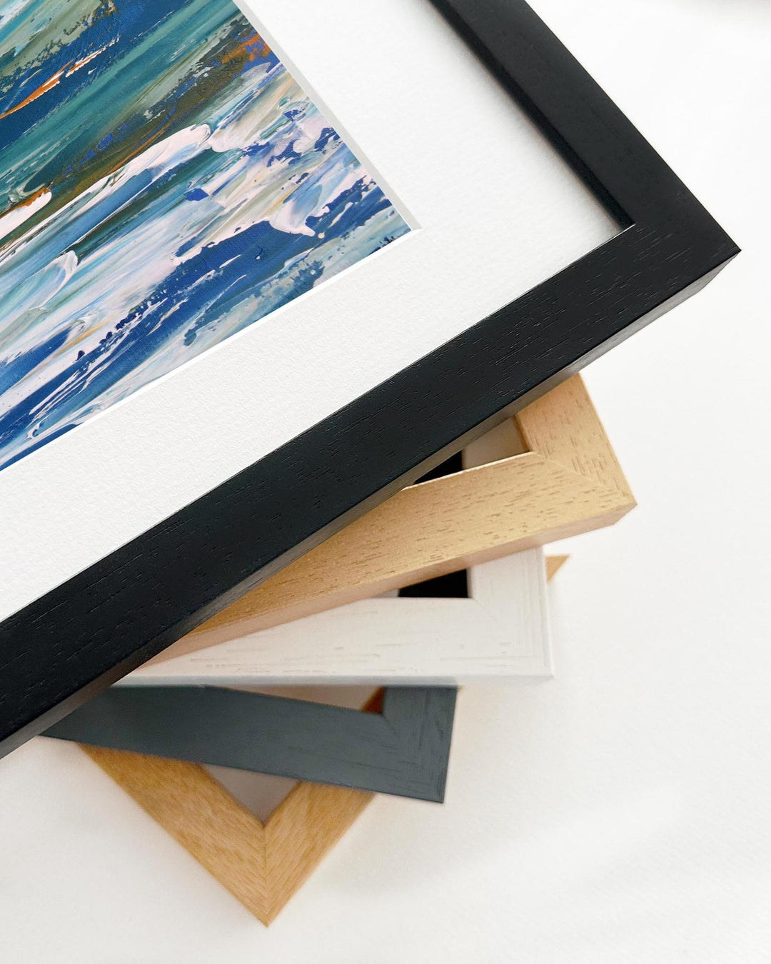 Framed abstract artwork with a stack of variously colored frames on a white background