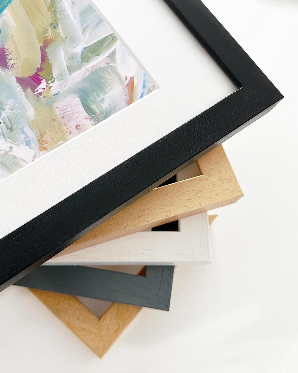Stack of variously colored picture frames on a white background