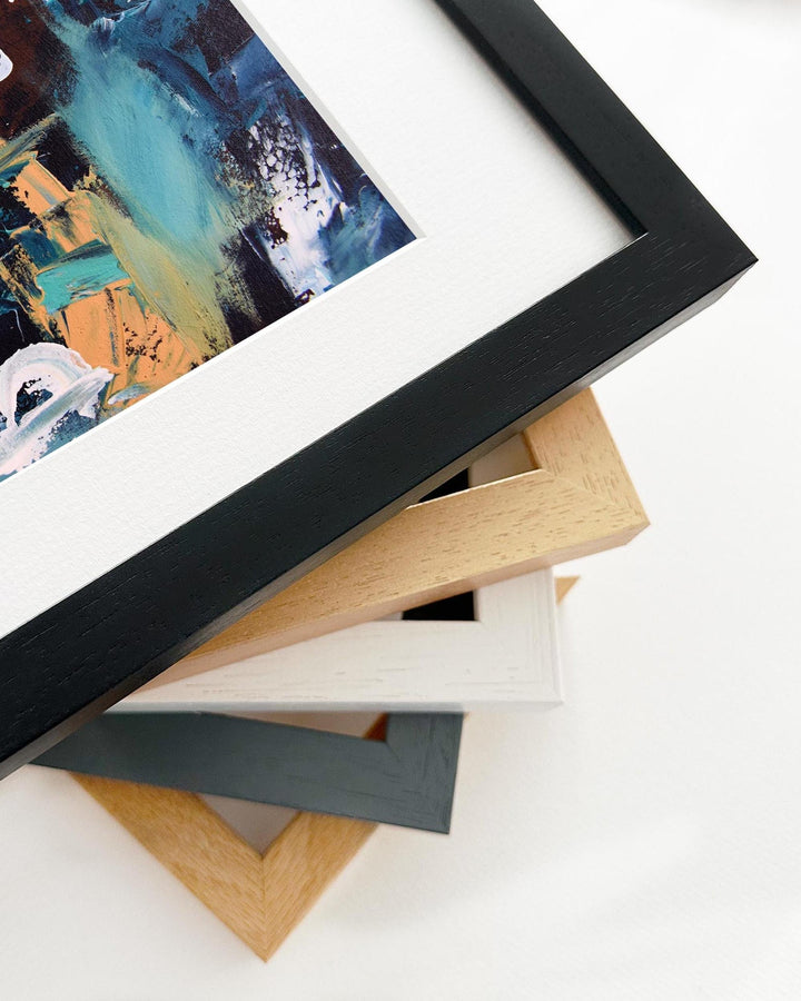 Framed abstract painting with a stack of variously colored frames on a white background