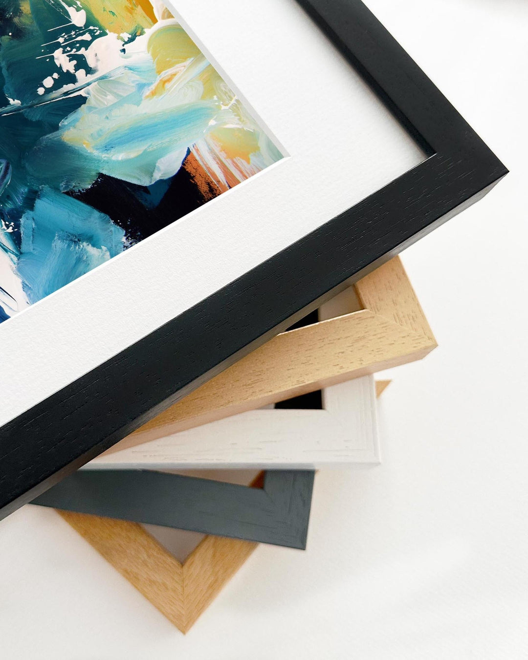Stack of variously colored picture frames on a white surface