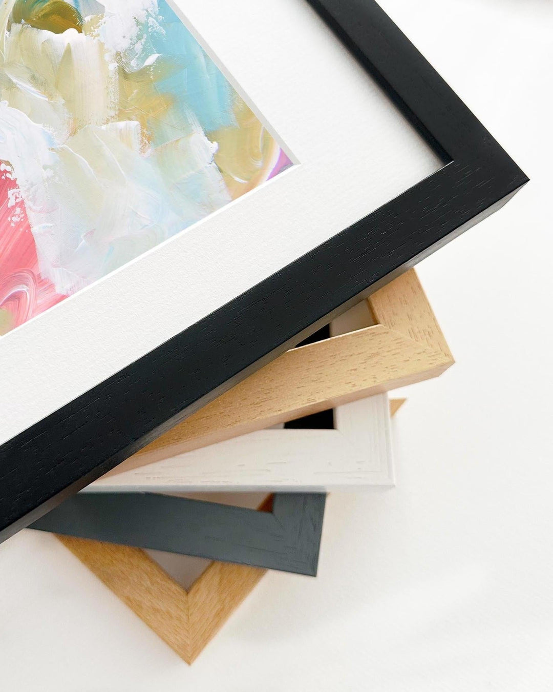 Stack of variously colored picture frames on a white surface