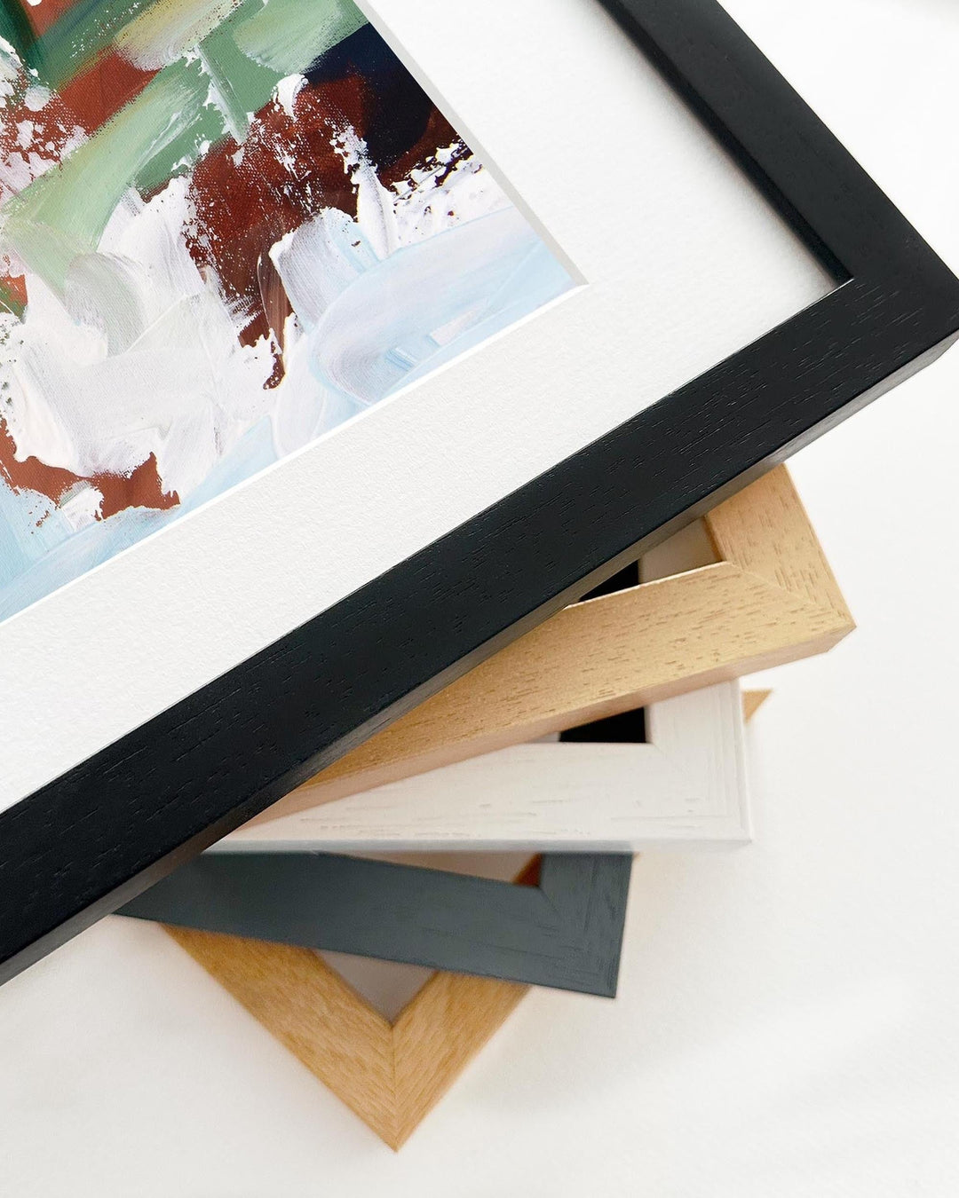 Stack of variously colored picture frames on a white surface