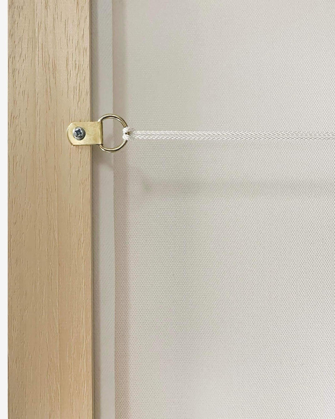 Close-up of a wooden door handle on a wooden door with a white wall in the background.