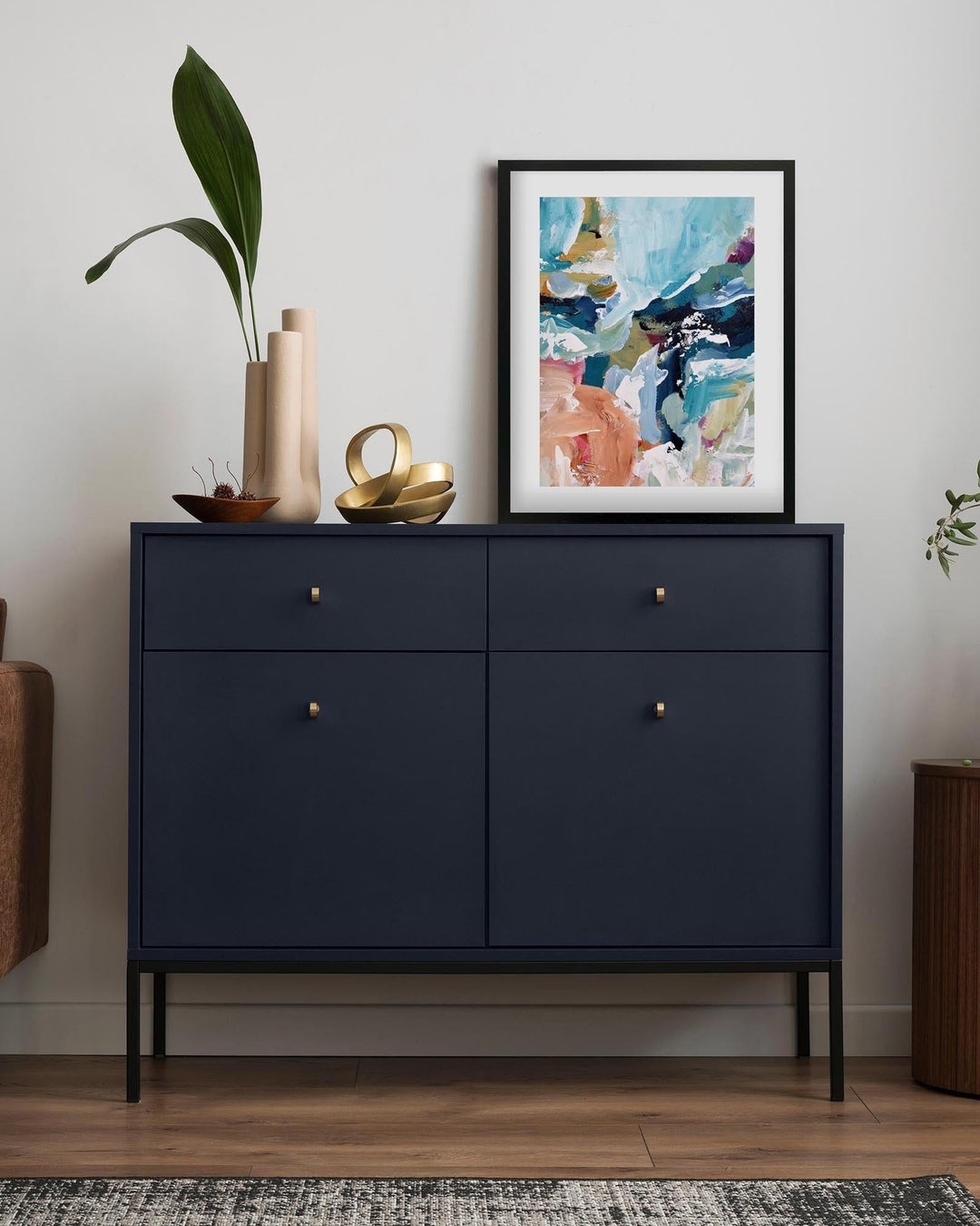 Navy blue dresser with decorative items in a room setting