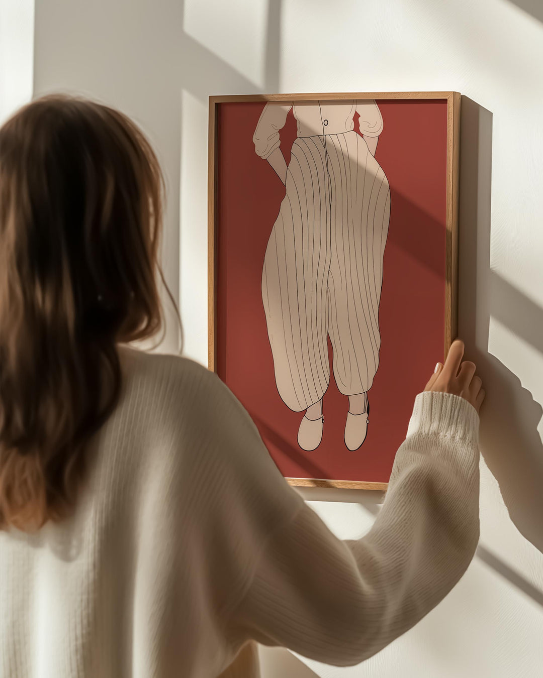 modern scandinavian poster print woman holding wall art picture on wall in frame