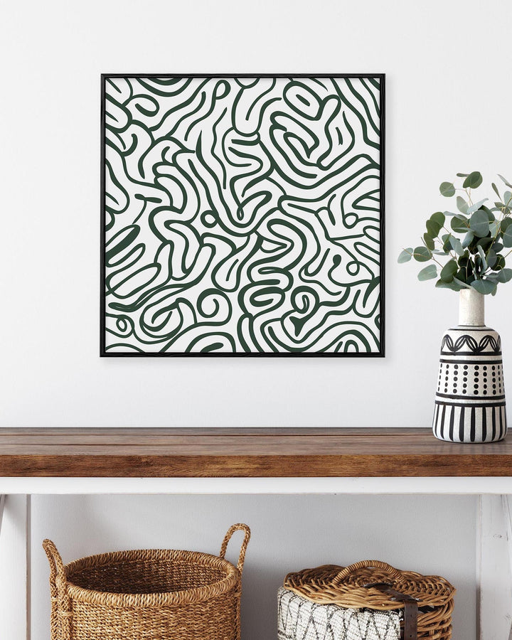 Abstract patterned artwork on a wall above a wooden table with decorative items.