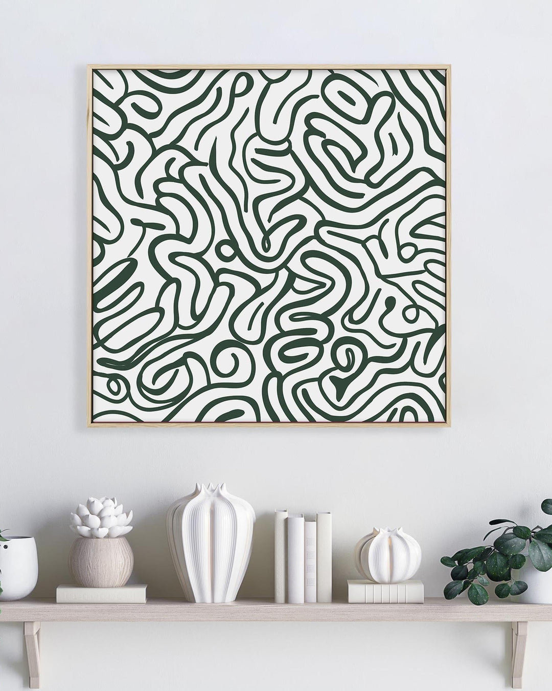 Abstract patterned artwork on a wall above a shelf with decorative items.