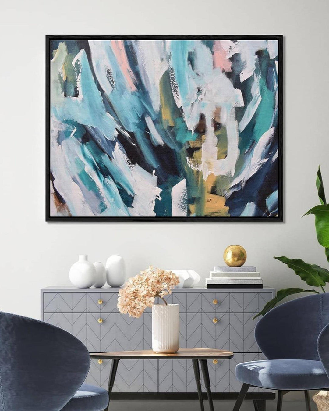 Abstract painting in a modern living room with furniture and decor.