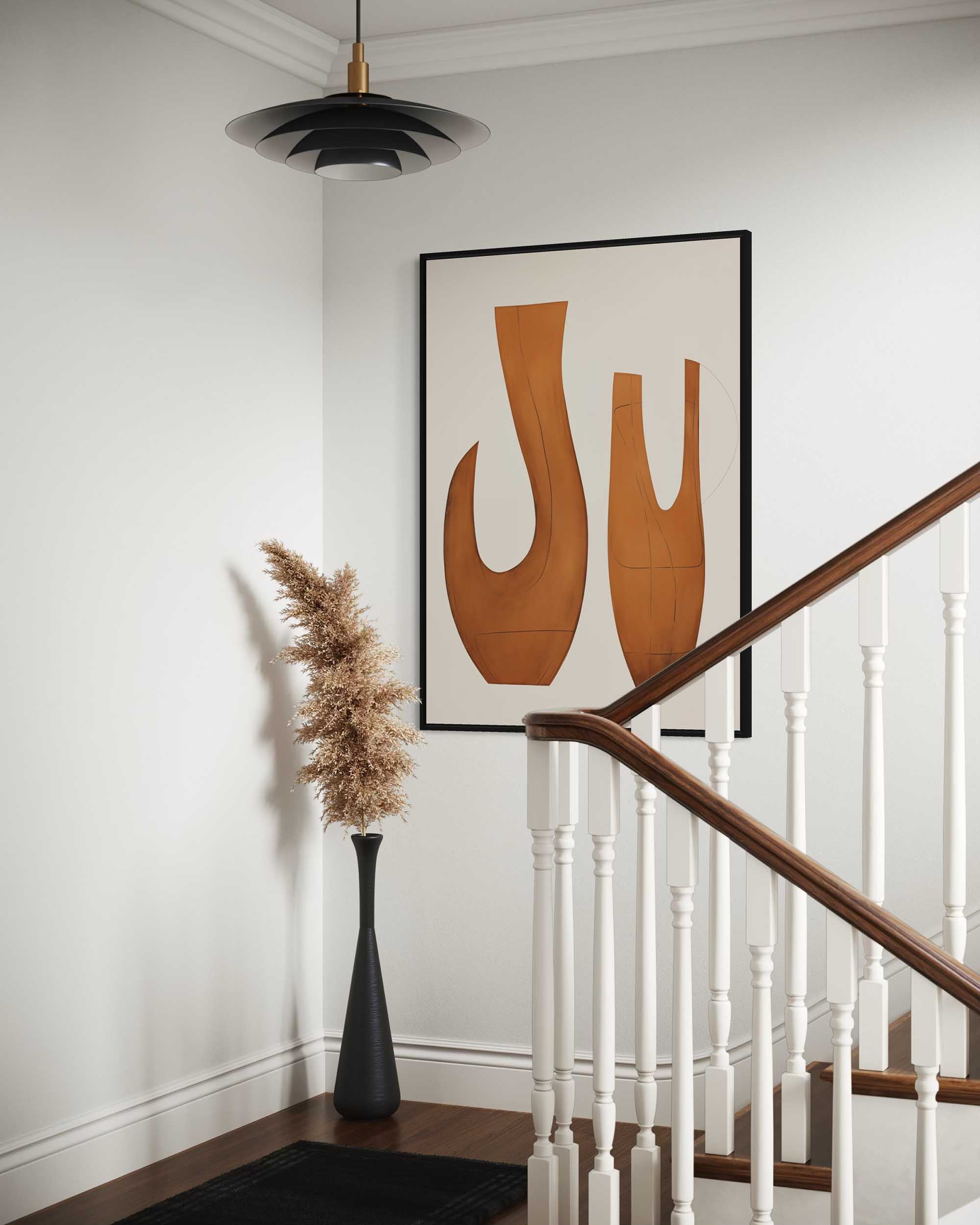 Staircase with a black vase and dried pampas grass, framed artwork on the wall.