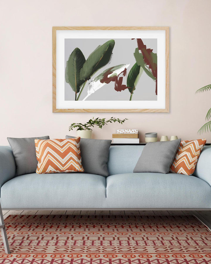 Living room with a light blue sofa, gray and orange patterned cushions, and a framed botanical print on the wall.