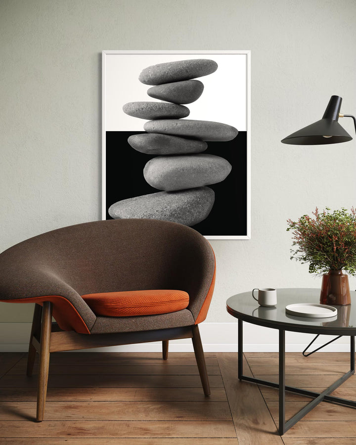 Modern interior with a brown and orange chair, coffee table, and abstract art of stacked stones.