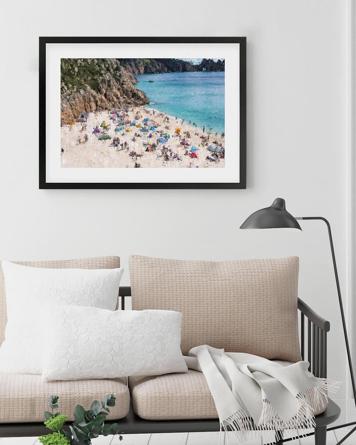 Framed photograph of a beach scene above a sofa in a living room.
