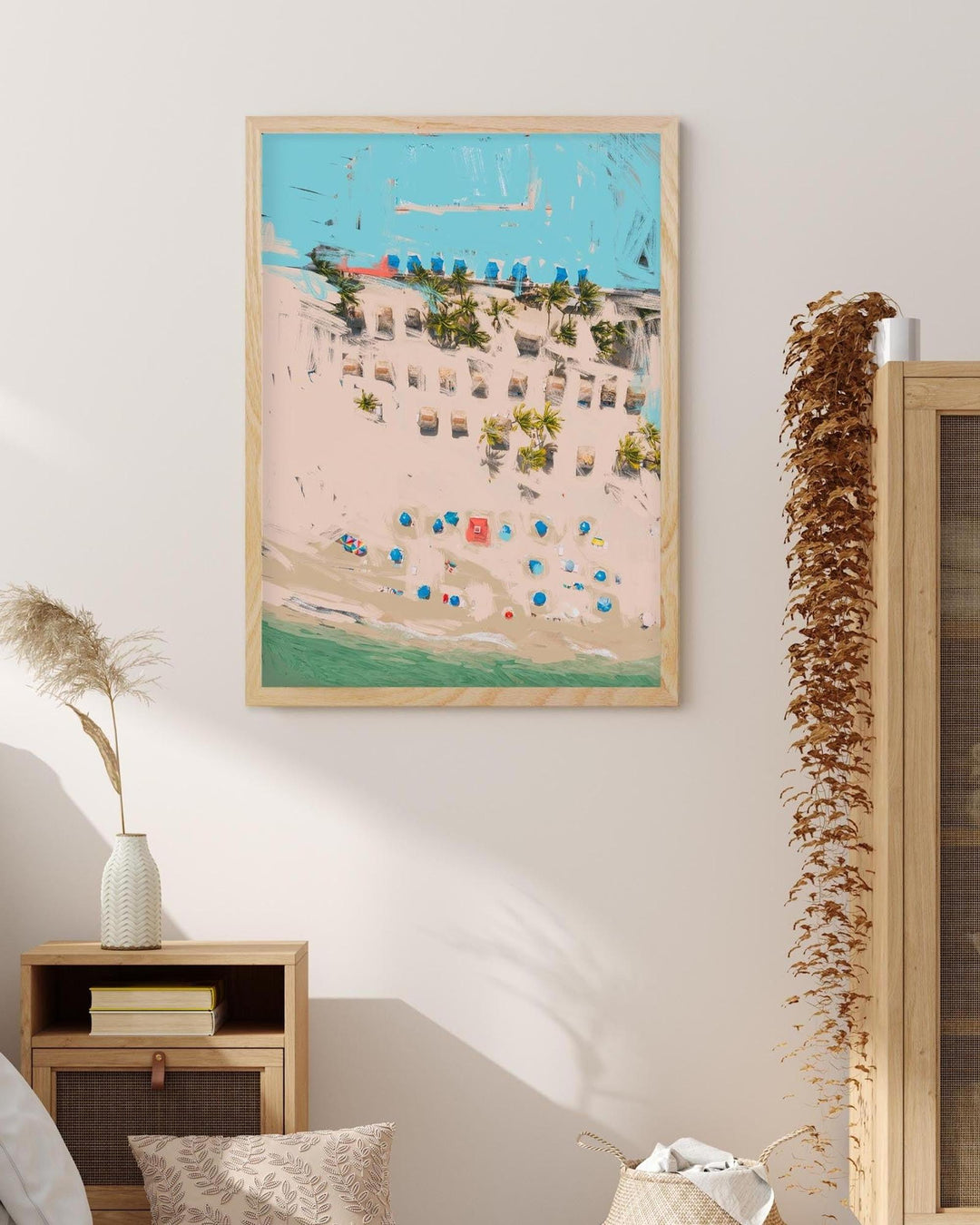 Framed artwork of a beach scene with colorful umbrellas on a wall in a room.