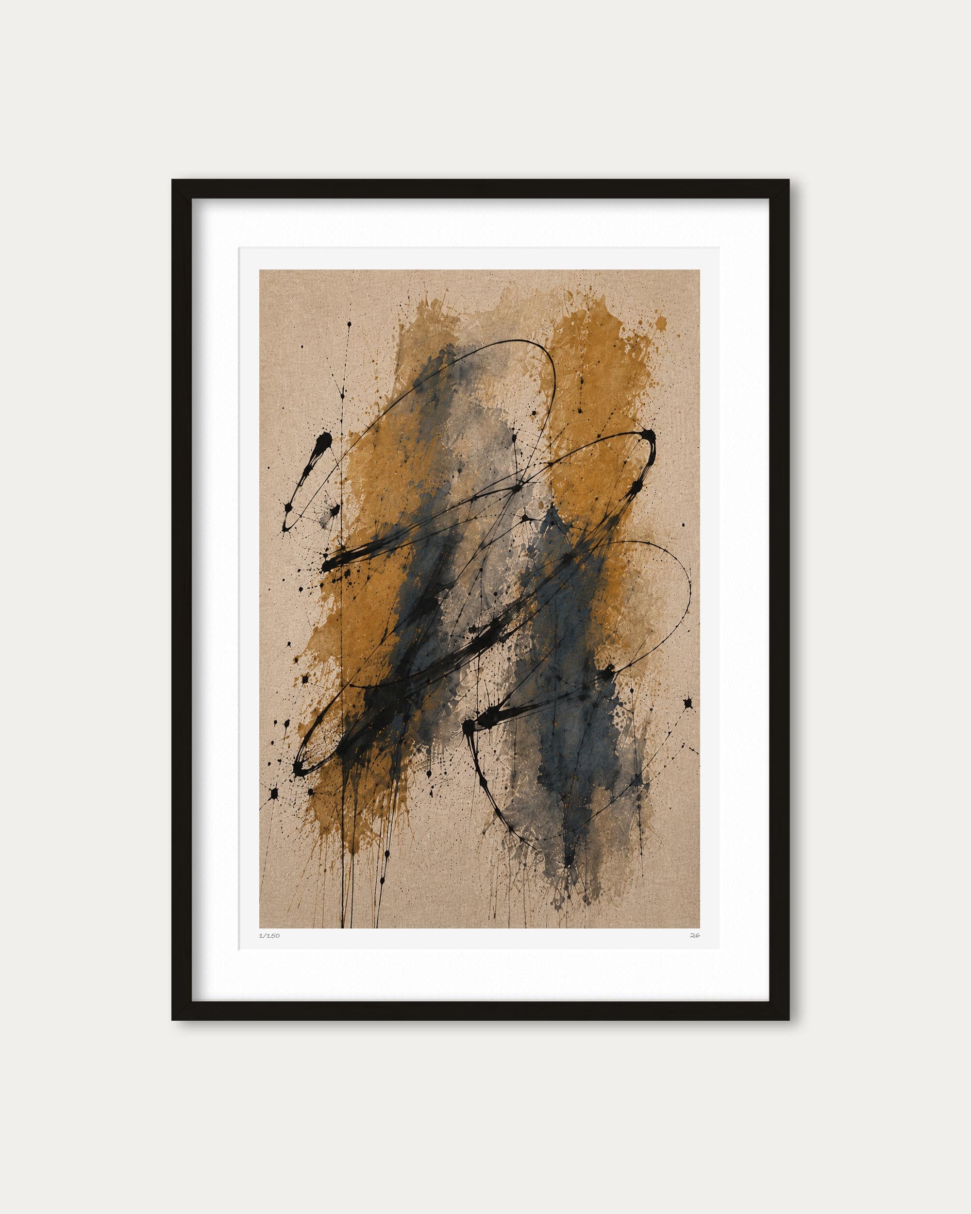 Framed abstract art print featuring expressive black paint splatters and drips over a warm tan and ochre background, presented in a black frame with a white mat against a light gray wall.
