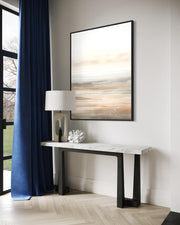 Modern interior with a console table, lamp, and abstract painting on a wall.