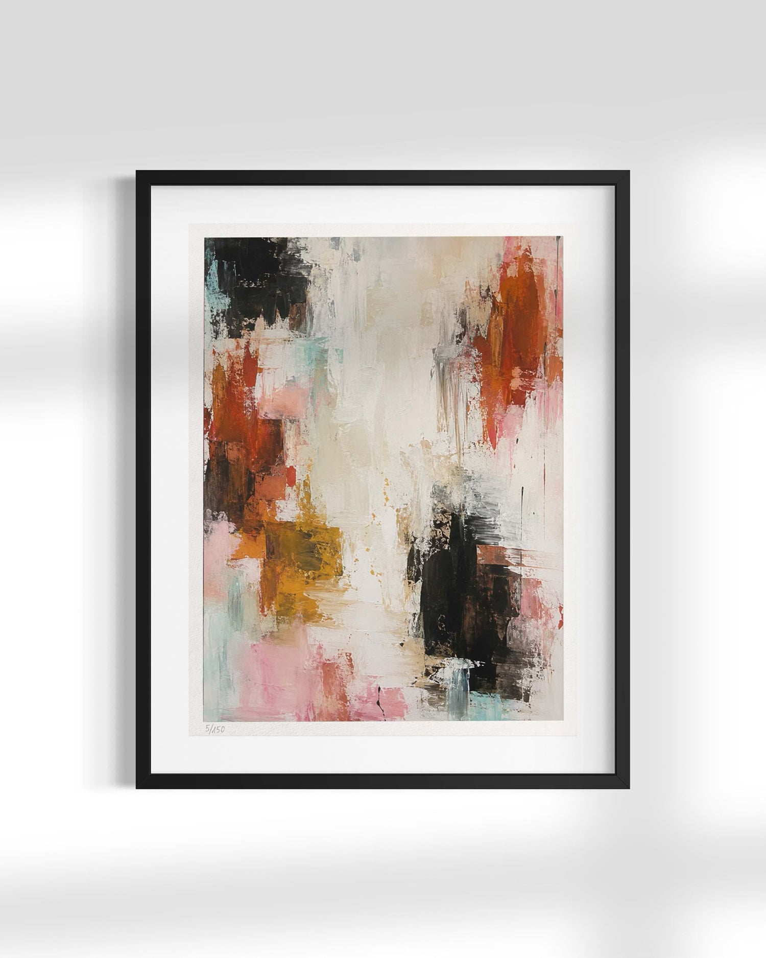 A framed abstract art print featuring a mix of black, red, pink, yellow, and light blue paint strokes on a cream background, presented in a black frame with a white mat against a light gray wall.