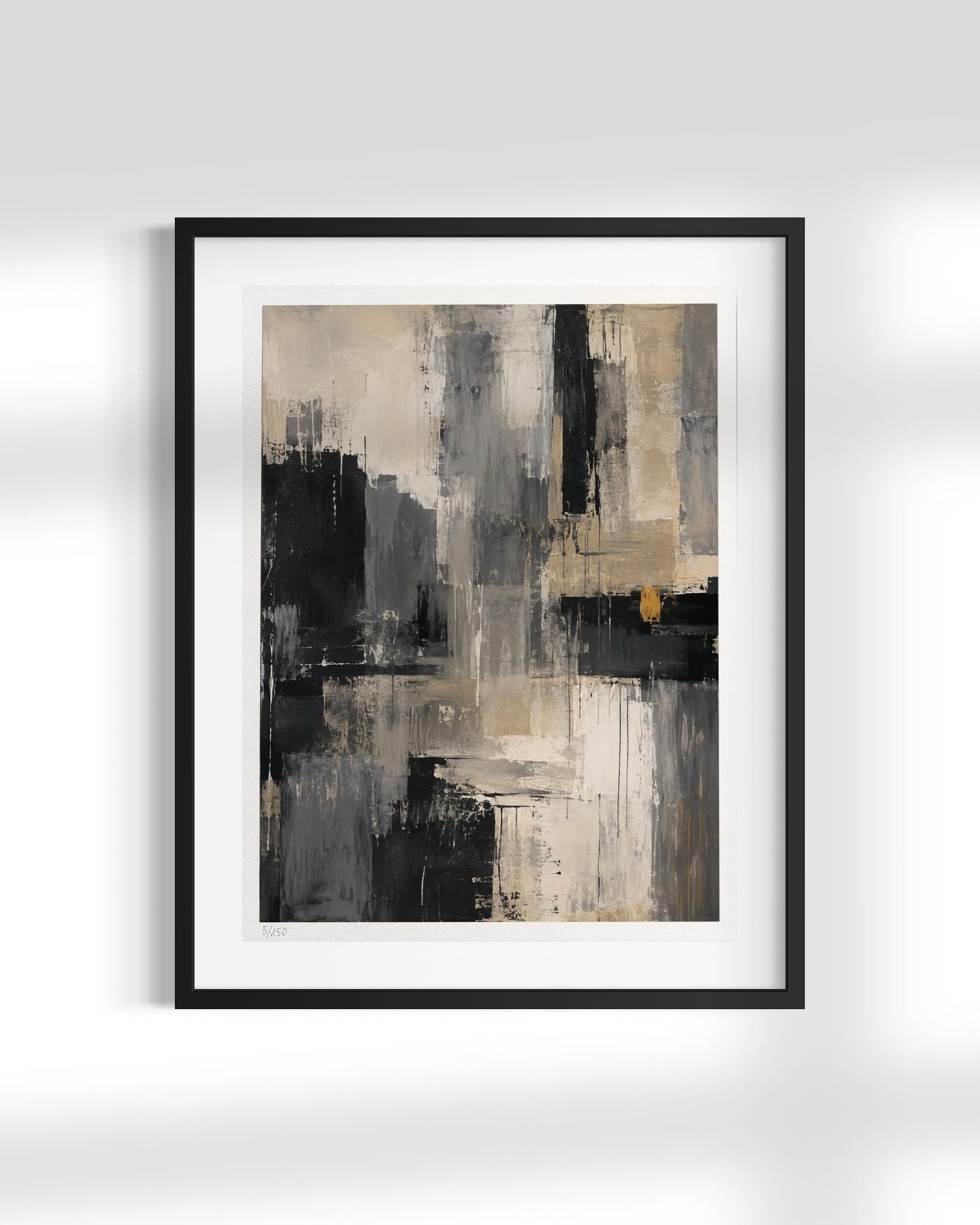 Framed abstract wall art featuring a modern composition of black, gray, beige, and white brushstrokes with a small warm accent, presented in a black frame with a white mat against a light gray wall.