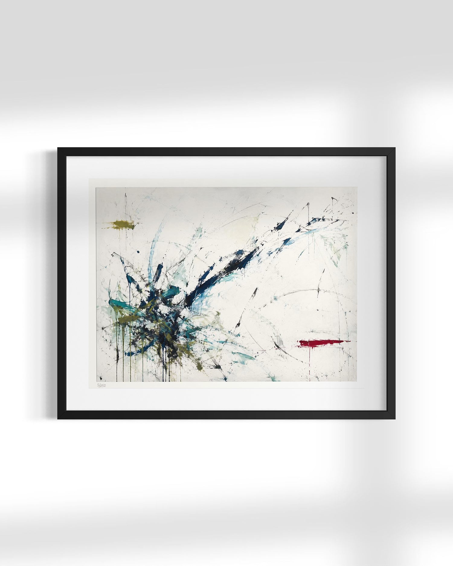 Framed abstract wall art hanging on a light gray wall, featuring expressive black, blue, teal, and red paint marks on an off-white background.