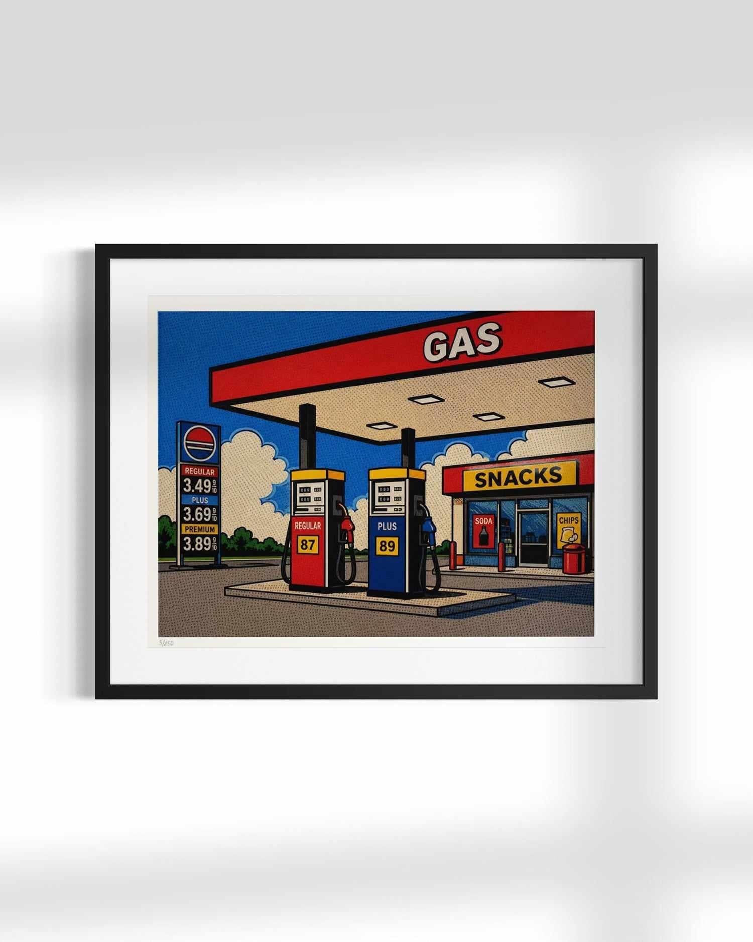 A framed pop-art style illustration of a gas station and convenience store, shown hanging on a light gray wall. The artwork features bold red, blue, yellow, and beige elements, with a black frame and white mat.