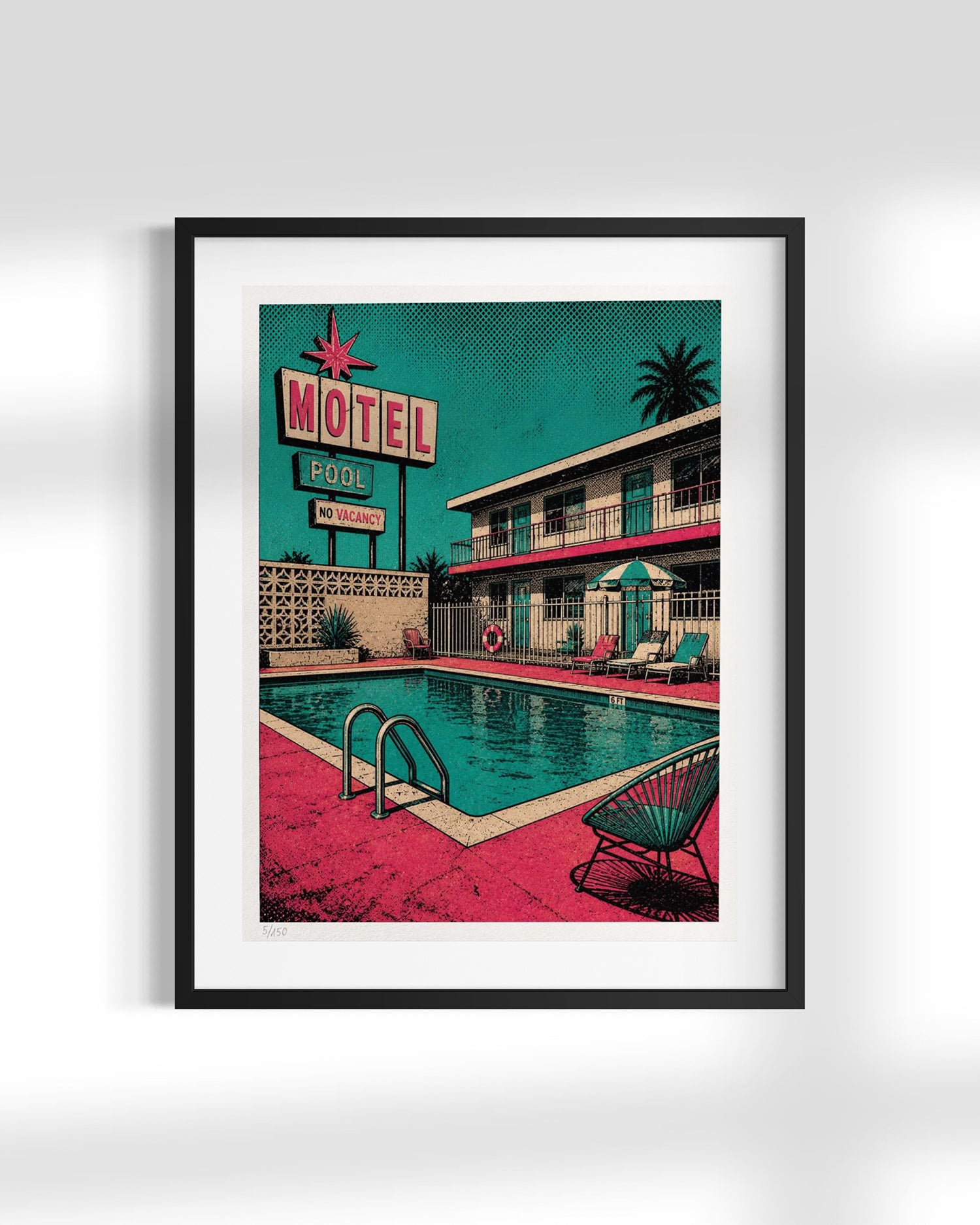 A framed art print featuring a retro 1950s motel pool scene with a teal sky, pink poolside area, and a two-story motel building, shown against a light gray wall.