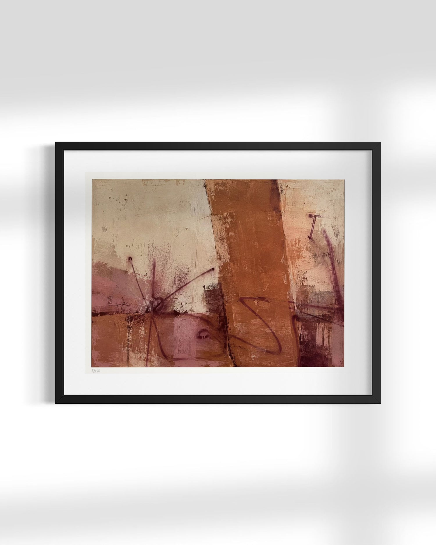 A framed abstract art print featuring earthy tones of brown, terracotta, and dusty pink with dark brushstrokes, presented in a black frame with a white mat against a light gray wall.