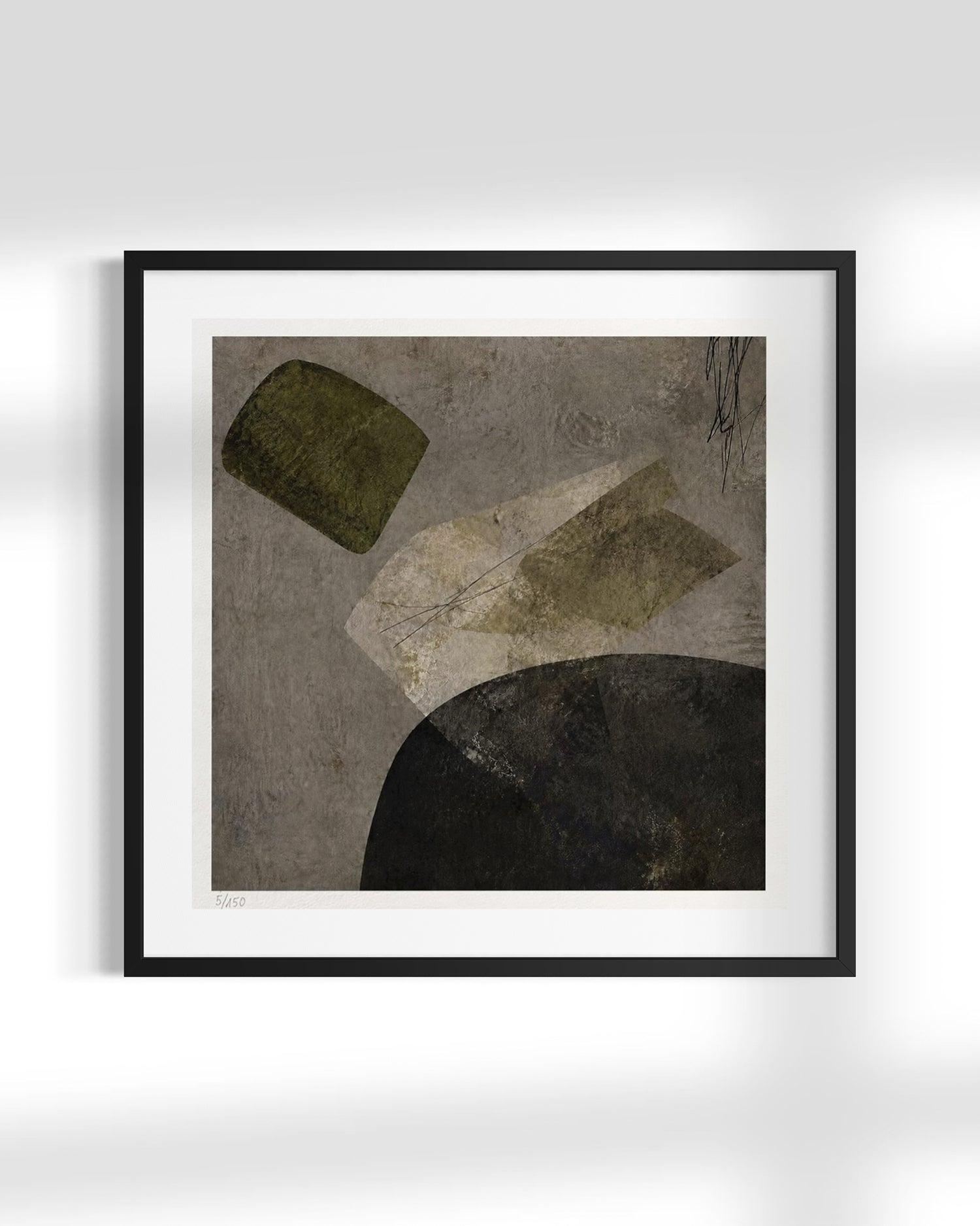 Framed abstract wall art with textured gray, olive green, beige, and black geometric shapes, shown in a black frame with white mat against a light gray wall.