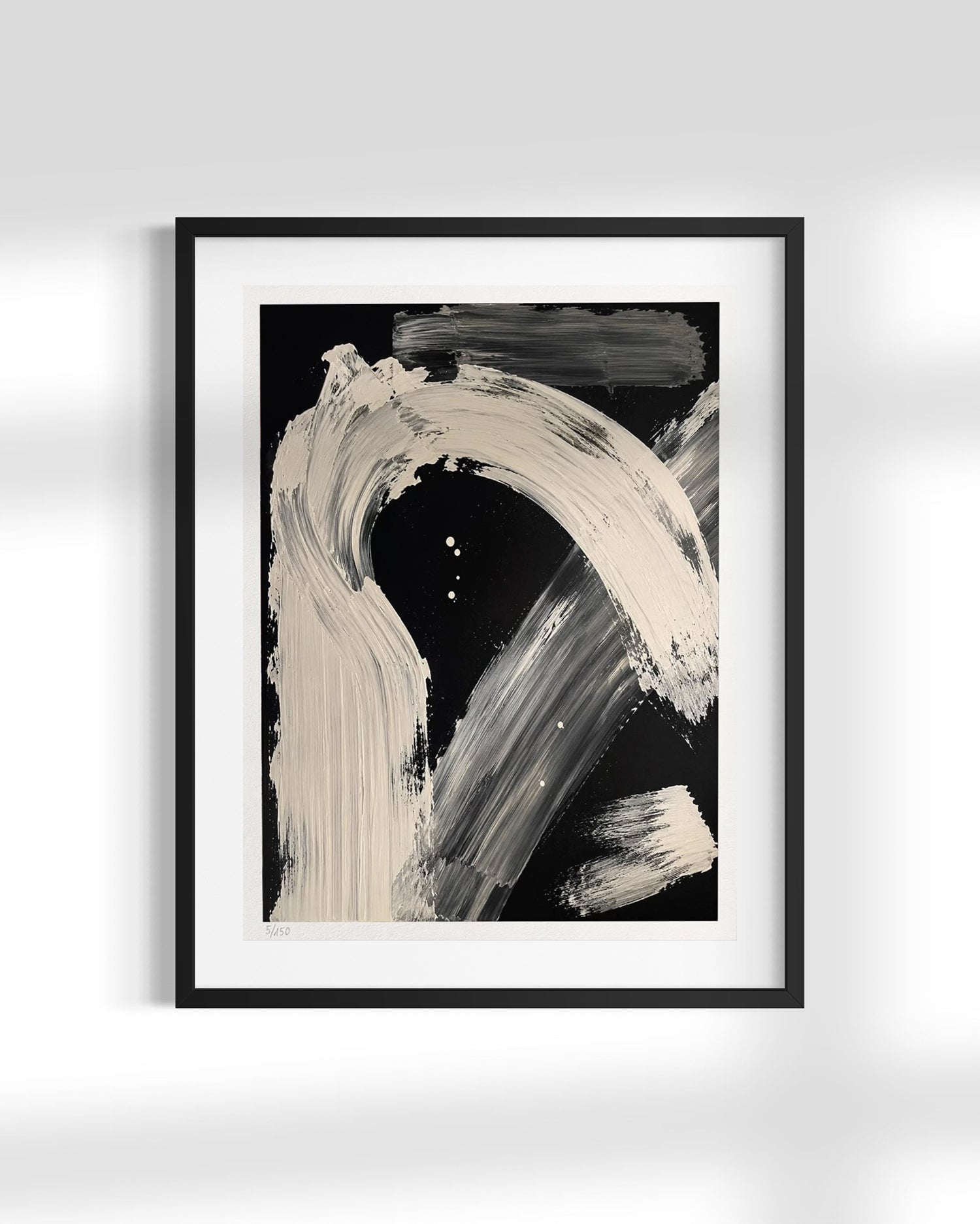 Framed abstract wall art featuring bold off-white and gray brushstrokes on a black background, presented in a black frame with a white mat against a light gray wall.