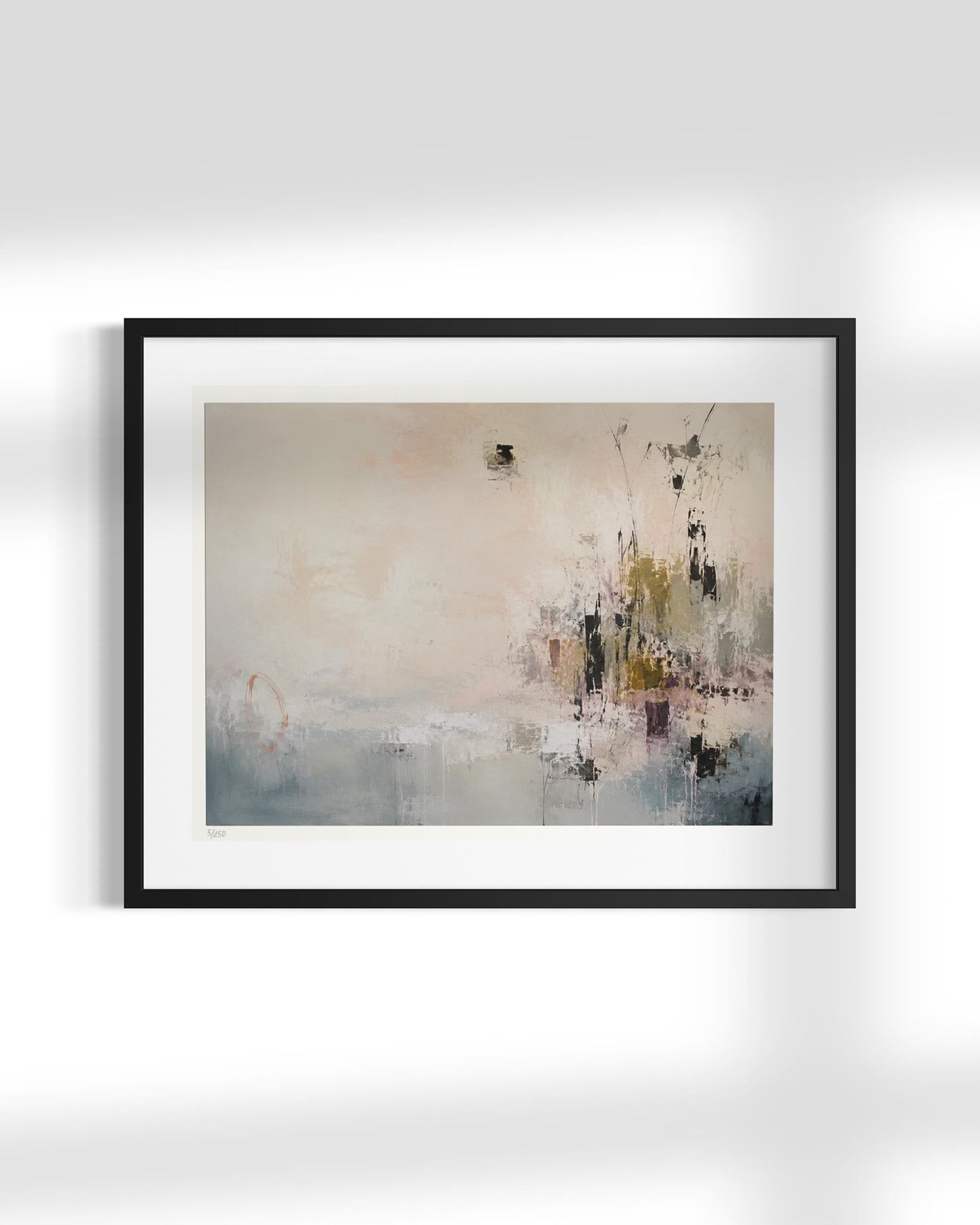 A framed abstract art print featuring soft, painterly brushstrokes in beige, gray, blue, and black, presented in a black frame with a white mat against a light gray wall.