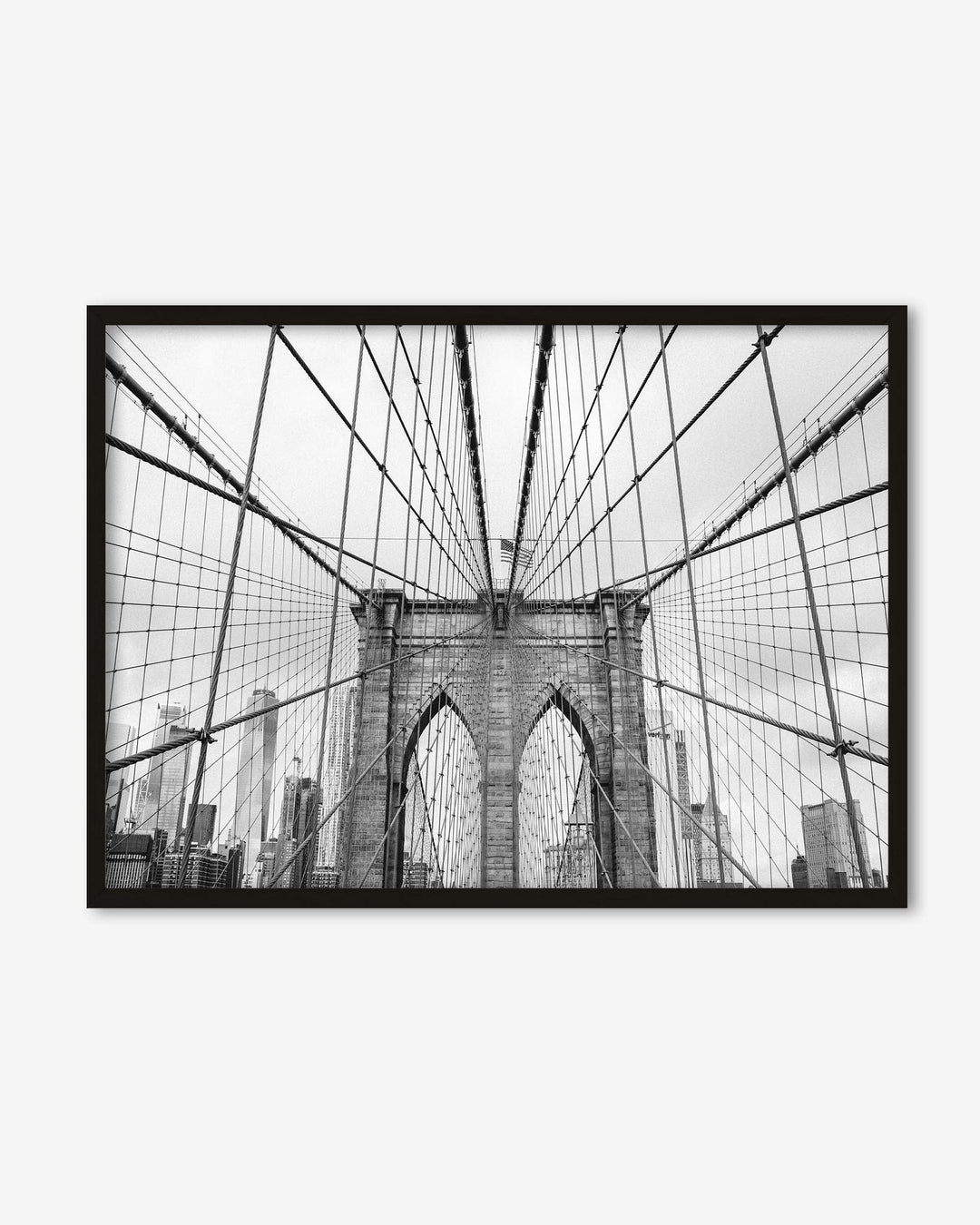 Framed black and white photo of the Brooklyn Bridge on a white wall