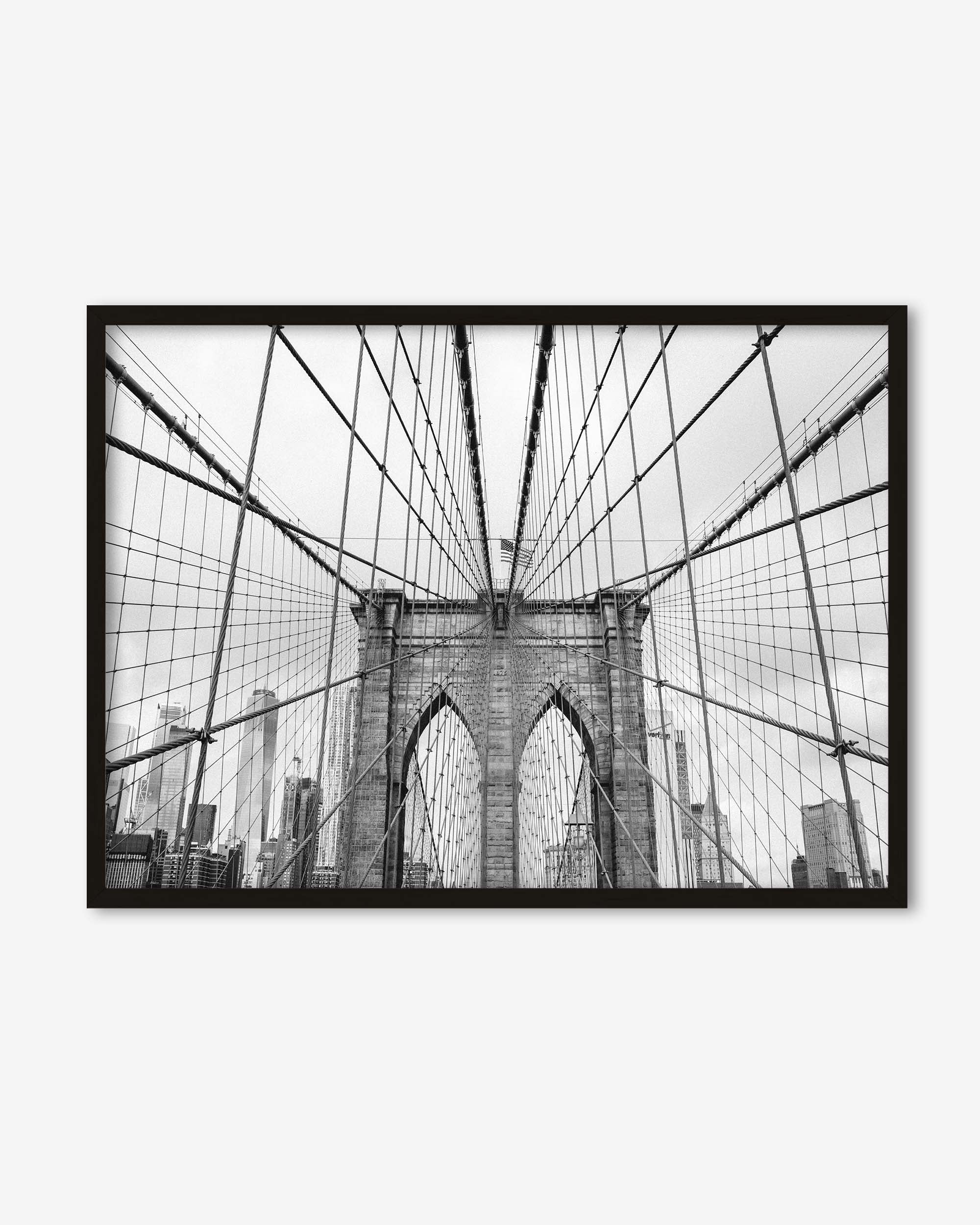 Framed black and white photo of the Brooklyn Bridge on a white wall