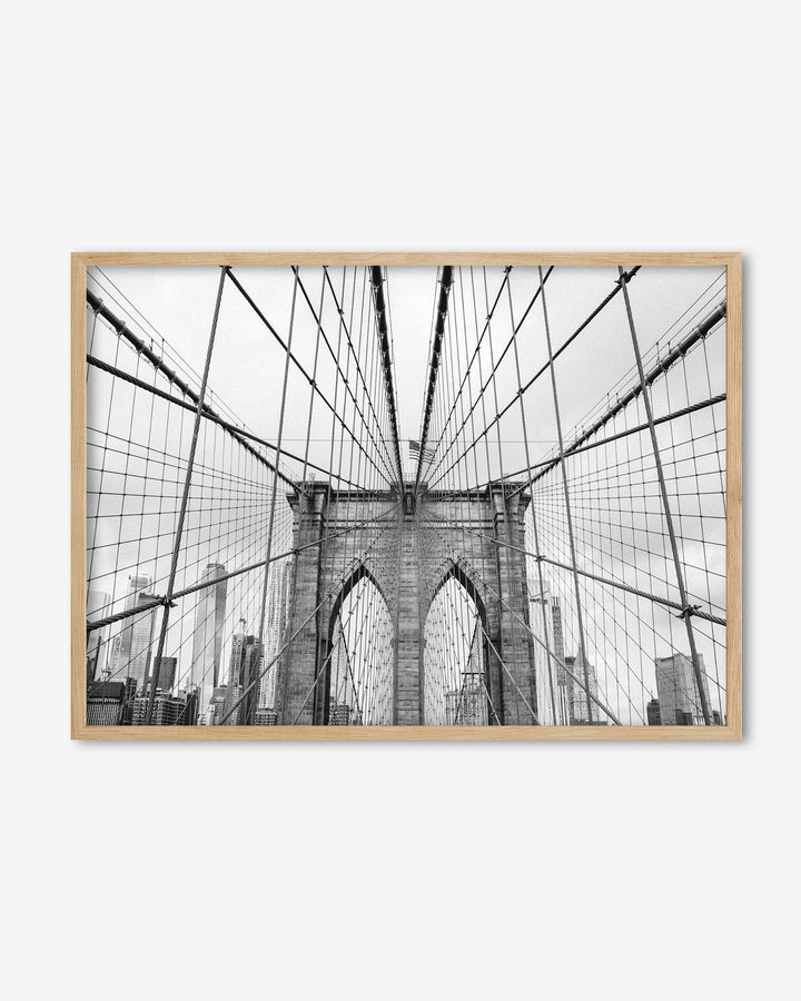 Framed artwork of the Brooklyn Bridge with a wooden frame on a white background