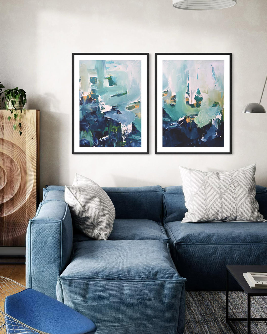 Blue sectional sofa in a living room with abstract art on the wall.