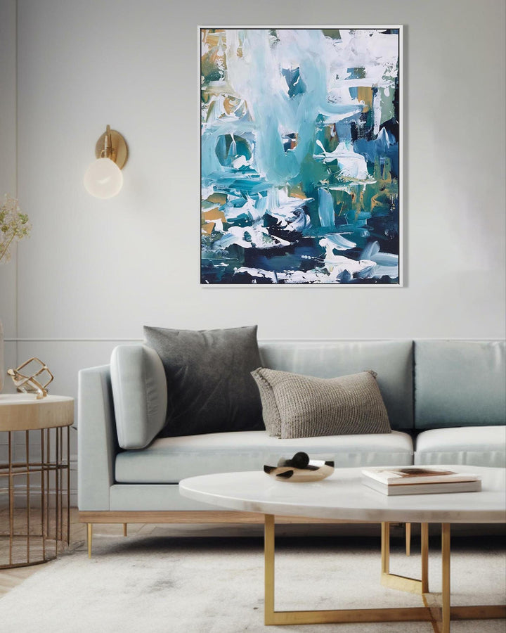 Modern living room with a gray sofa, abstract painting, and side table.