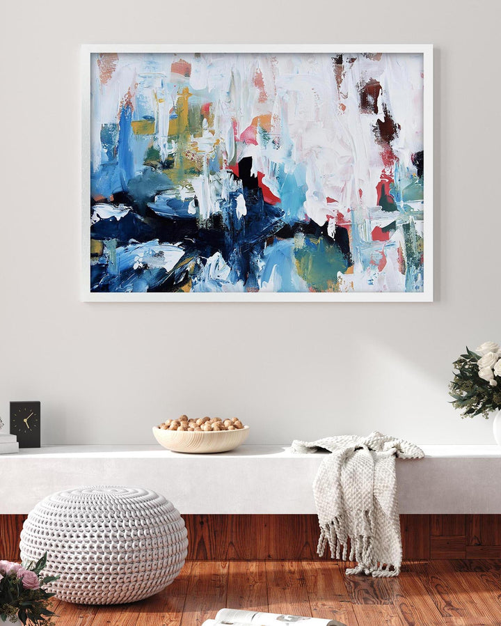 Abstract painting in a modern living room setting with a bench and decorative items.