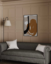 Abstract art piece on a wall above a gray sofa with a lamp and decorative pillows.